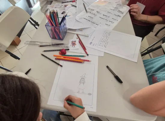 Dessin d’une sorcière et feuilles du récit sur la table de l’atelier